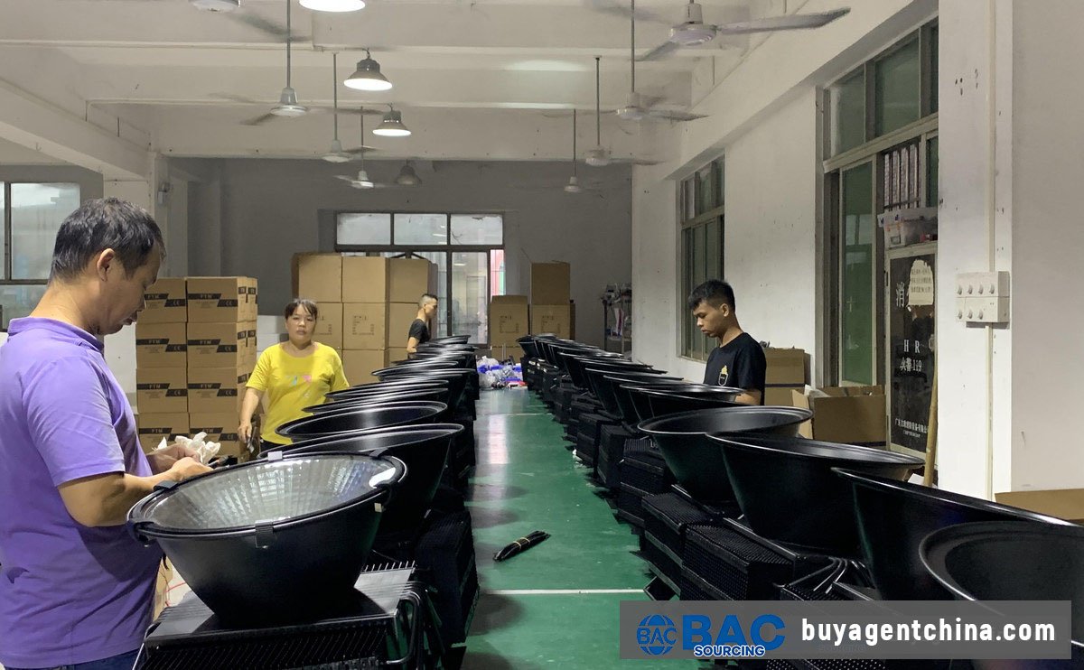 04 Workers assembling flood lights on a production line — worth verifying on a factory video or visit