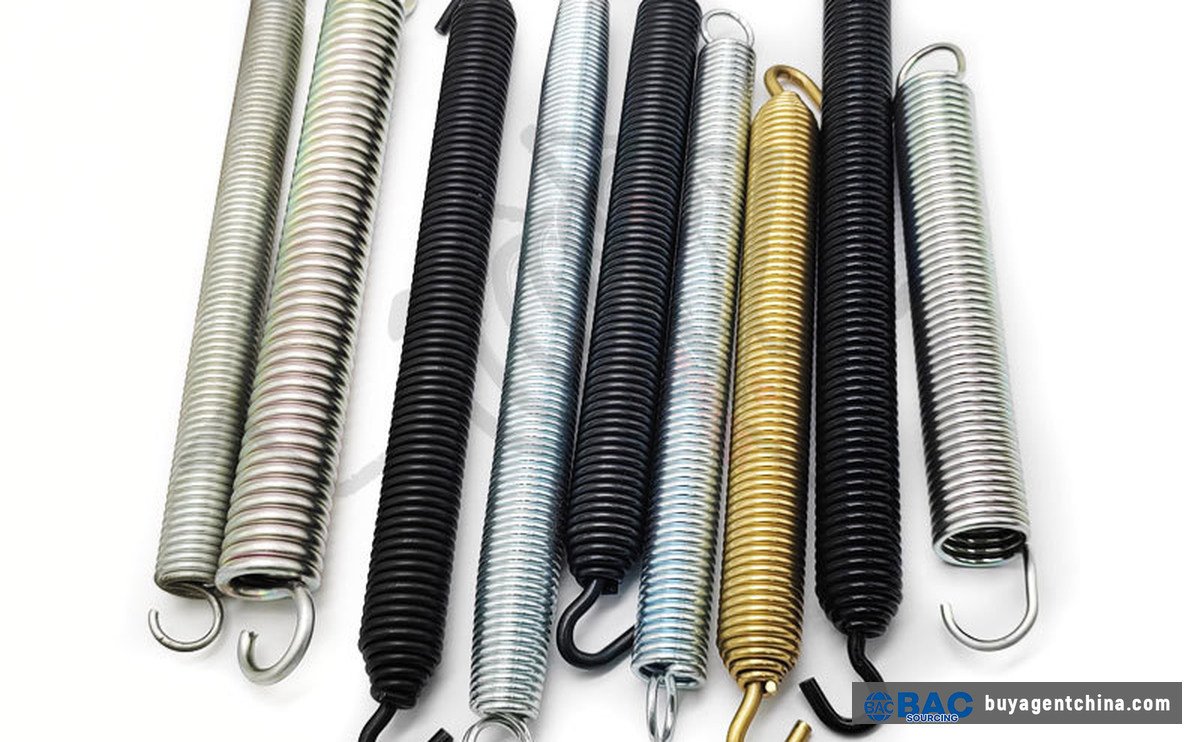 Extension springs in black e-coat, galvanized and yellow-zinc finishes — finish follows the environment